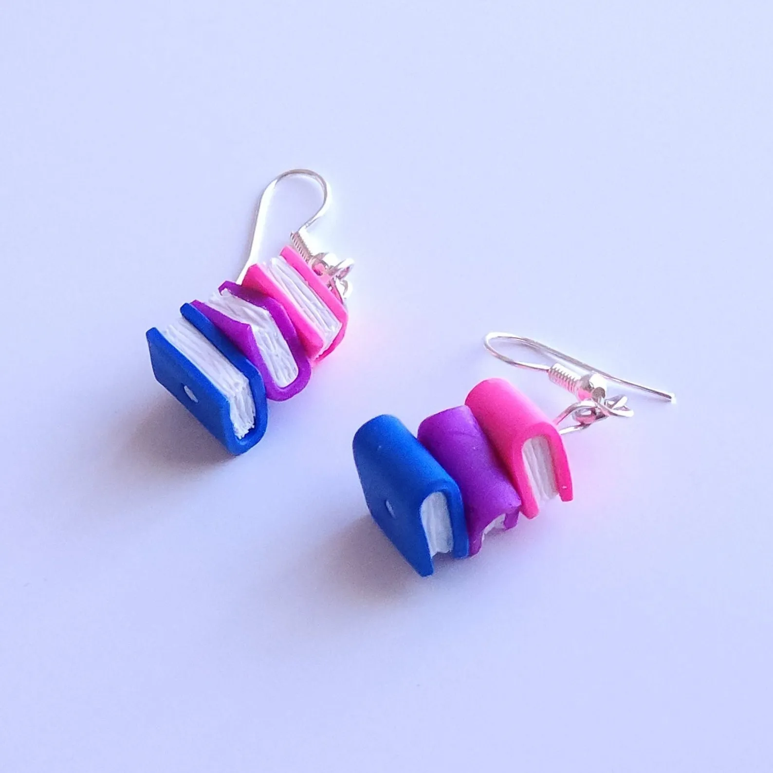 polymer clay earrings of a stack of books in bisexual flag colors
