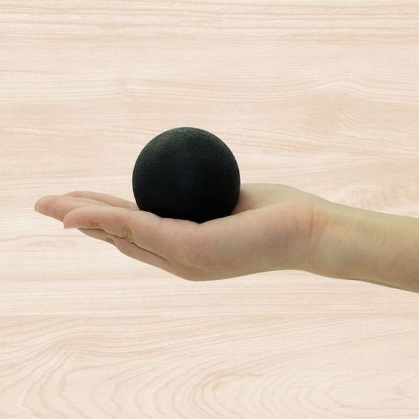 hand holding a black lacrosse ball