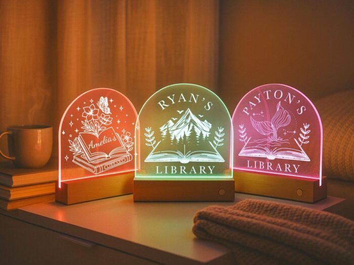image of three lit signs with icons and personalized messages like "Amelia's Library," etc. The signs are translucent with colorful light shining through them.