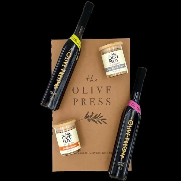 two black glass bottles of olive oil and two small clear glass bottles of spice blends